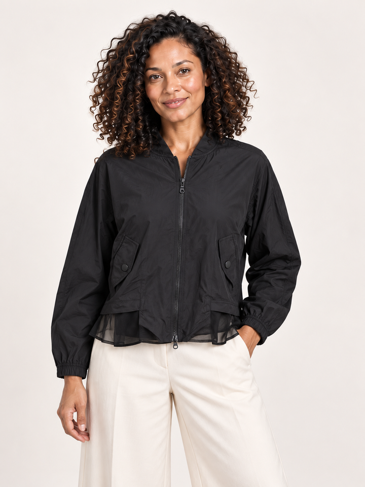 Kozan Aspi Jacket in Preto, black bomber with two way zip and mesh hem, front view on model